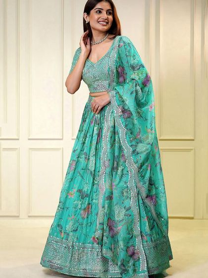 Feel like a dream in this turquoise organza lehenga. The color is so refreshing, and the sequin work adds just the right amount of sparkle for a reception or cocktail party.