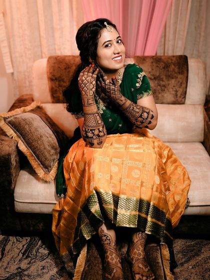 A happy bride getting ready, her hands and feet beautifully adorned with traditional mehendi.