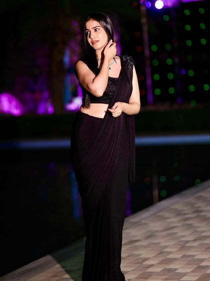 Another angle of the black saree, showing off the modern draped style and my confident pose by the water.