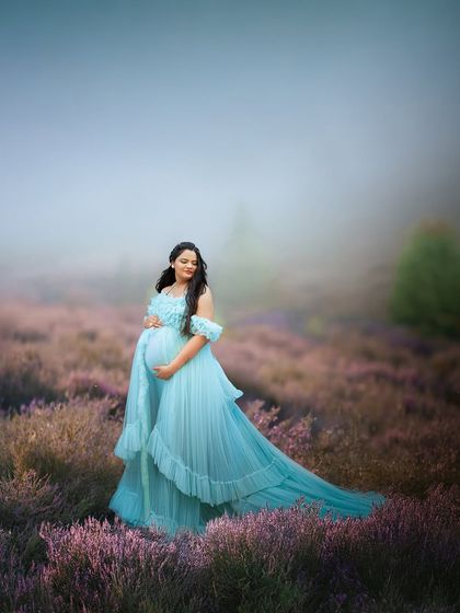 A breathtaking portrait in a field of lavender. The soft blue gown and misty background create a serene and dreamlike atmosphere for this solo maternity photo.