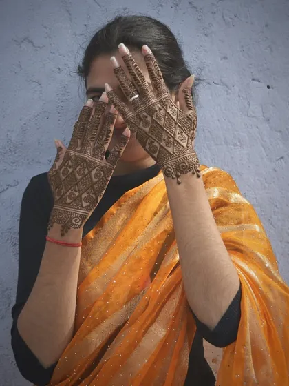 Another playful shot of the client, giving a clearer view of her beautifully stained traditional jaal-patterned mehndi.
