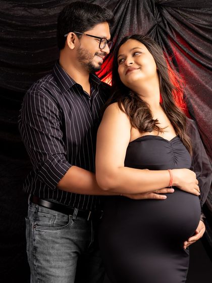 An intimate portrait of the same couple. They gaze at each other lovingly, creating a candid and emotional moment within the dramatic studio setting.