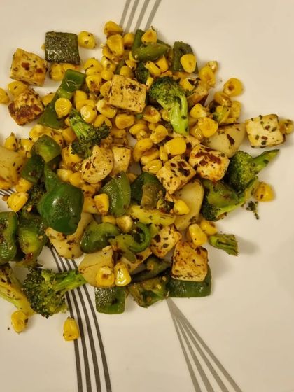 A simple and quick vegetarian stir-fry. This plate has pan-fried paneer (tofu), corn, broccoli, and capsicum. It's high in protein and fiber, making it a perfect post-workout meal or a light dinner. Healthy eating can be this easy.
