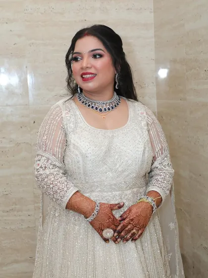A classic reception look in a beautiful white gown. The makeup is elegant and polished, with a focus on radiant skin.