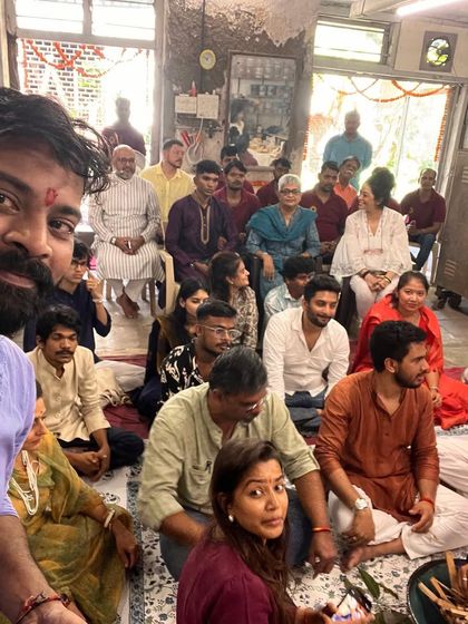 A selfie capturing the vibrant atmosphere of the Ganesh puja, with the whole community gathered in the background.