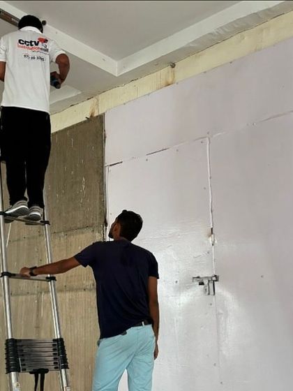 Our team at work on a commercial site. We use telescopic ladders to reach high ceilings and ensure cameras are placed for optimal coverage.