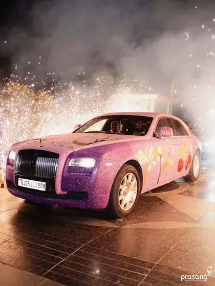 A grand exit in a custom-decorated Rolls Royce. I arrange for unique touches like this sparkling, floral-painted luxury car, complete with pyrotechnics, to ensure the couple's exit is as spectacular as their entrance.