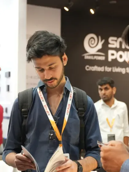 A group of attendees reviews a brochure while speaking with an exhibitor. The expo floor is a hub for information exchange and lead generation.