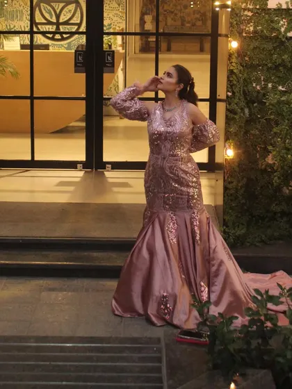 The pink mermaid gown photographed outdoors, showing how the satin train catches the evening light.