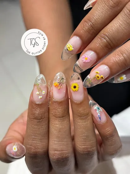 A closer look at the encapsulated dried flower nails, showing the variety of tiny, colorful flowers used in the design.