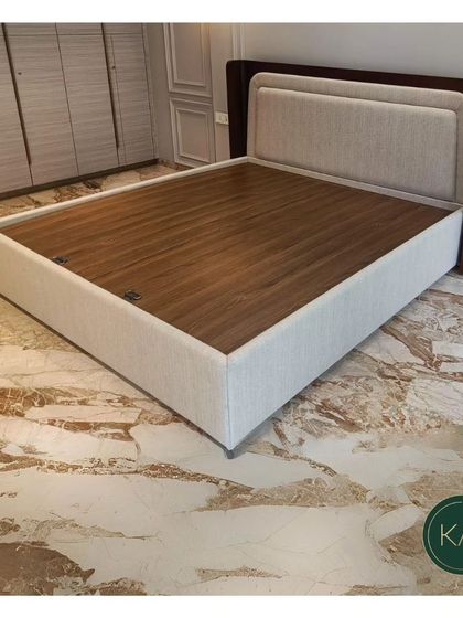 Another angle of the dual-panel upholstered bed, showcasing its clean lines and the elegant contrast between the fabric, wood, and the room's marble floor.