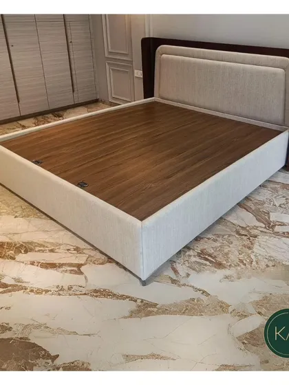 Another angle of the dual-panel upholstered bed, showcasing its clean lines and the elegant contrast between the fabric, wood, and the room's marble floor.