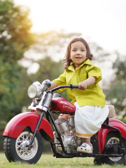 Let your little one's personality shine. This outdoor portrait captures a toddler's happy and adventurous spirit with one of our fun props, a mini toy motorcycle.