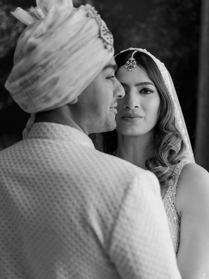 A black and white portrait where the bride looks directly at the camera, her expression full of confidence and love. It’s a powerful and intimate shot that highlights the connection between the couple.