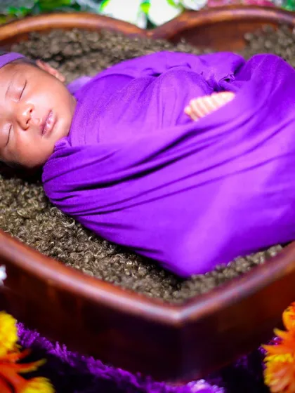 A heart-melting shot of a newborn sleeping in a heart-shaped wooden bowl. I use soft fabrics and floral accents to create a beautiful and serene setting.