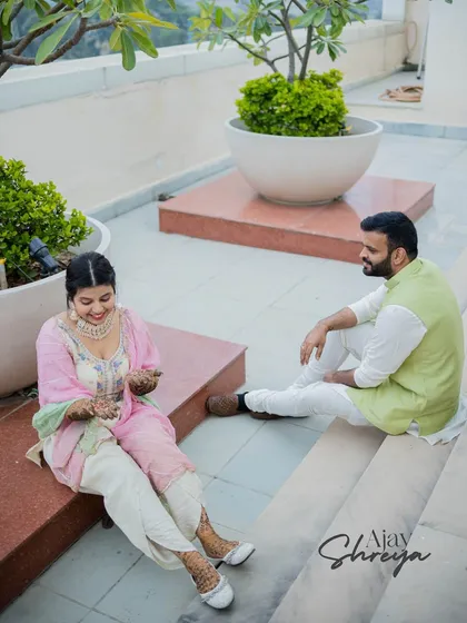 A candid shot of a couple sharing a moment on a terrace. This photo captures the relaxed and informal side of pre-wedding celebrations.