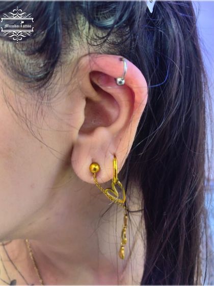 A classic helix piercing with a simple ball closure ring. This is a timeless look that we execute with precision and care.