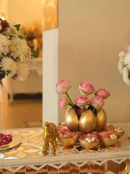 A closer view of the floral centerpiece on the mirror console. The combination of white chrysanthemums, pink roses, and golden accents creates a look of pure elegance.