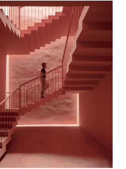 A monochromatic view of the staircase, emphasizing the geometric play of lines and the texture of the materials. This space is designed to be a sculptural experience in itself.