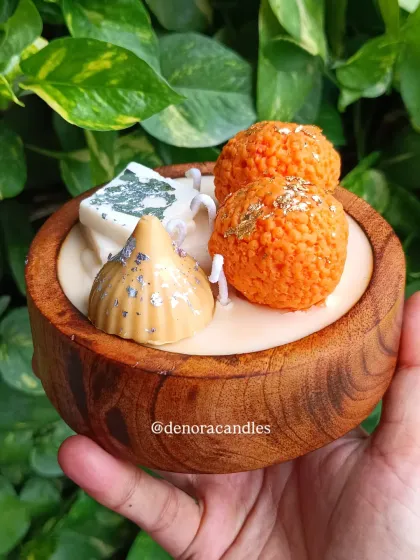 A hand-held view of the dessert platter candle, giving a sense of its size and craftsmanship.