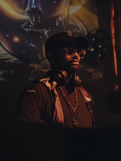 A portrait of me in the zone, with abstract visuals projected in the background. My sets are an audio-visual experience, designed to be fully immersive.