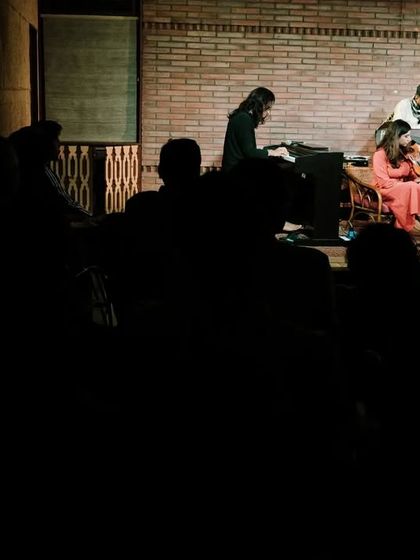 A wide shot showing the silhouetted audience watching REFUGE perform at the Jazz Festival. This view emphasizes the intimate connection between the performers and listeners at Koota.