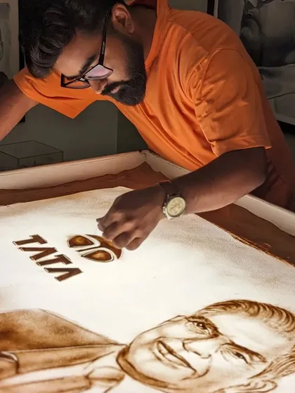 Adding the iconic Tata logo to my sand art tribute. The details matter in telling a complete story.