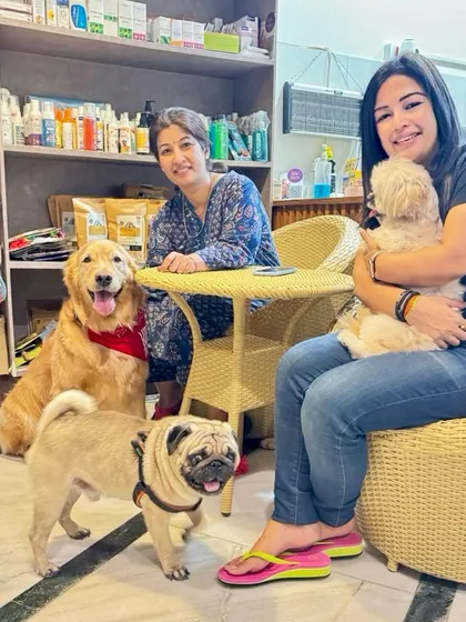 Look at these happy faces. This picture captures the essence of our community, with pet parents and their furry children, including a Golden Retriever, a Pug, and a Shih Tzu, all enjoying their time together. This is the family I always dreamed of building.
