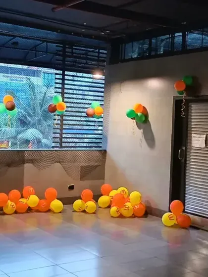 The start of a dinosaur-themed party setup, with balloon bunches scattered around the venue to build excitement.