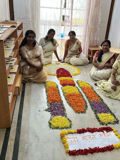 Our teachers sit beside a unique Onam pookalam shaped like the Chandrayaan rocket, blending tradition with national pride. Mera Bharat Mahan!