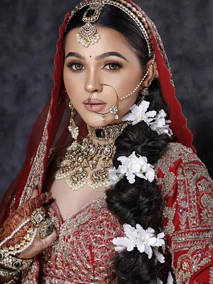 This is my signature bridal look. It features a perfectly blended soft glam eye, sculpted features, and a bold lip, all tied together with a base that looks like real skin. The hair is adorned with fresh flowers for a traditional touch.