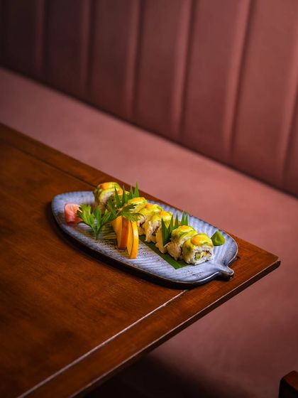 A beautifully plated Uramaki roll on a wooden table, embodying the fusion of Japanese precision and our warm, rustic ambiance.