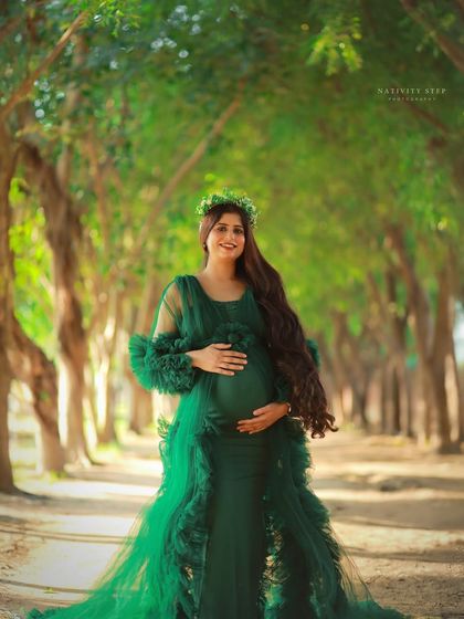 A fairytale-like outdoor portrait in a magnificent green tulle gown. The natural archway of trees creates a beautiful, enchanting frame for the mother-to-be.
