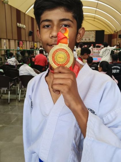 A close-up of a hard-earned gold medal from the New Delhi District Taekwondo Championship. Each medal represents a story of effort and excellence.