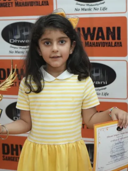 A young student proudly holds her certificate and trophy.