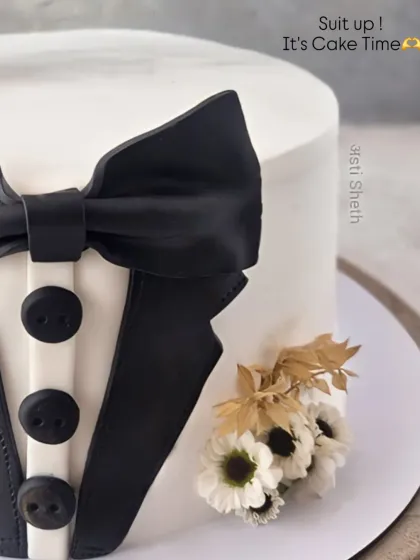 A close-up of the tuxedo cake, showing the sharp details of the suit and the small floral boutonnière.