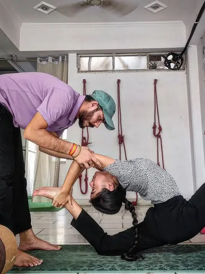 Here, I am providing a hands-on adjustment during a backbending session. My focus is on precise alignment to ensure students can safely deepen their practice, open up their spine, and build strength without injury. This is the core of our Iyengar-inspired therapeutic approach.
