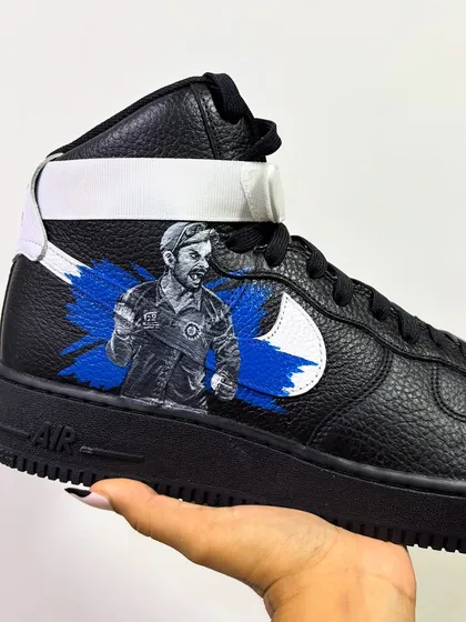 A custom pair of black Nike Air Force 1 Mids painted with a portrait of Indian cricket star Virat Kohli.