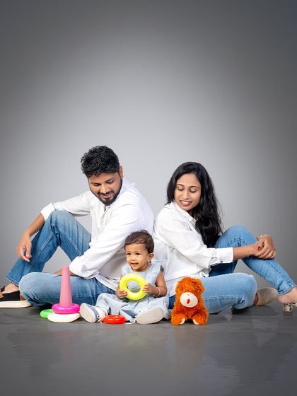 A relaxed and happy family portrait. By letting kids play with their favorite toys, we can capture genuine smiles and interactions.