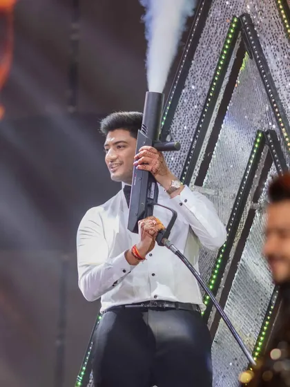 When the groom is a true 'Hero No. 1'. This shot captures the peak energy of his sangeet performance, complete with a CO2 gun to hype up the crowd.