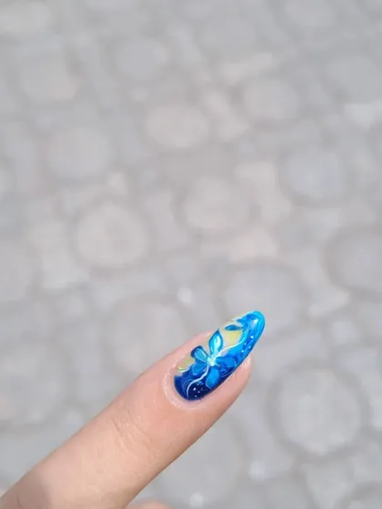 A magical, glowing blue butterfly hand-painted on a single nail. It's all in the details!