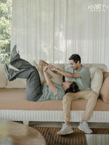 A sweet, playful moment on the couch. This image captures the comfortable intimacy and easy laughter that comes with being with your favorite person.