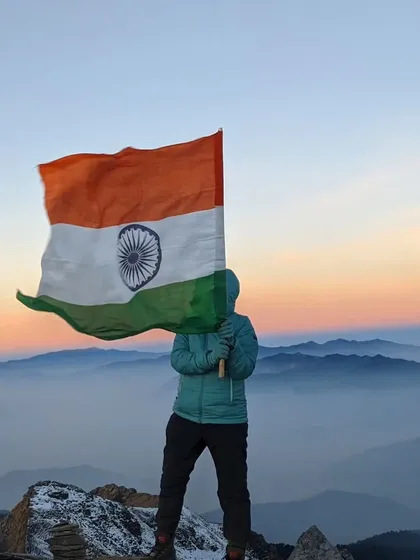 Our flag soaring high at the Kedarkantha peak at 12,500 ft, with the sunrise painting the sky. A moment of pure pride and triumph.