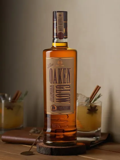 The label on this Oaken Glow whisky bottle seems to glow from within. I set this up in a cozy, rustic scene with cocktails in the background to show the product in a real-life serving situation.