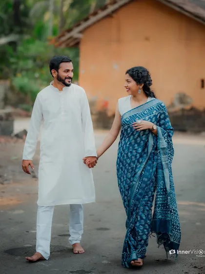 The couple walks hand-in-hand through a village, sharing a smile. This photo captures the simple, beautiful moments of a traditional countryside pre-wedding shoot.