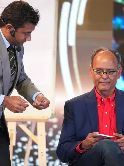 Performing an act for a seated volunteer at the MetroBrands event. This demonstrates the versatility of my show, which can be adapted for various stage setups and levels of interaction.
