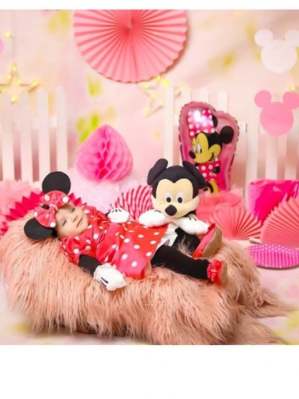 The cutest Minnie Mouse. This custom-made red and white polka dot romper with matching mouse ears is a perfect and comfortable choice for a Disney-themed newborn photoshoot.