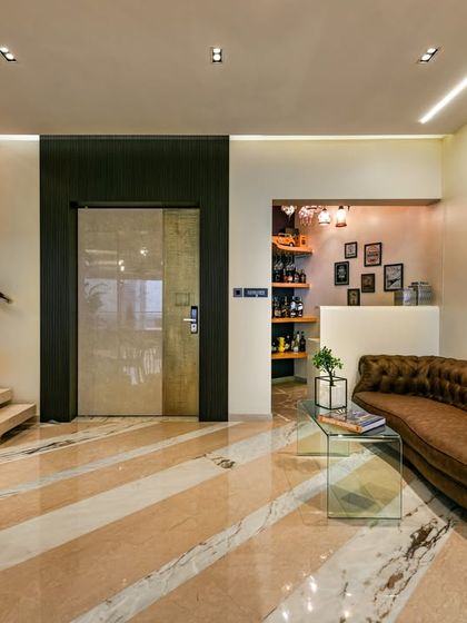 I had the unique joy of designing this Mumbai home twice. The reimagined entry lobby unfolds into an informal living space layered with textures, from a lush tropical green wall to a diagonally patterned floor that defines the area with elegance.