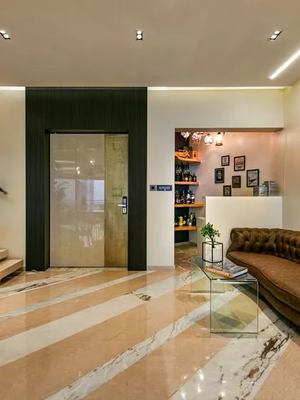 I had the unique joy of designing this Mumbai home twice. The reimagined entry lobby unfolds into an informal living space layered with textures, from a lush tropical green wall to a diagonally patterned floor that defines the area with elegance.