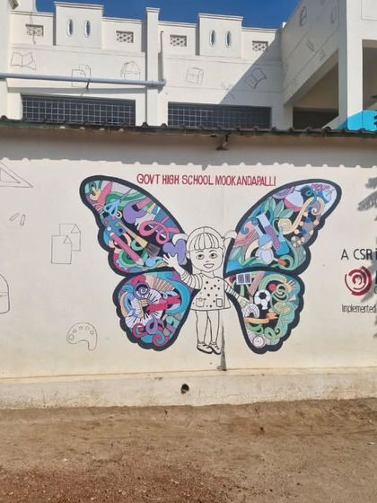 A butterfly girl mural in progress at a government high school. The wings are filled with educational doodles related to school subjects.